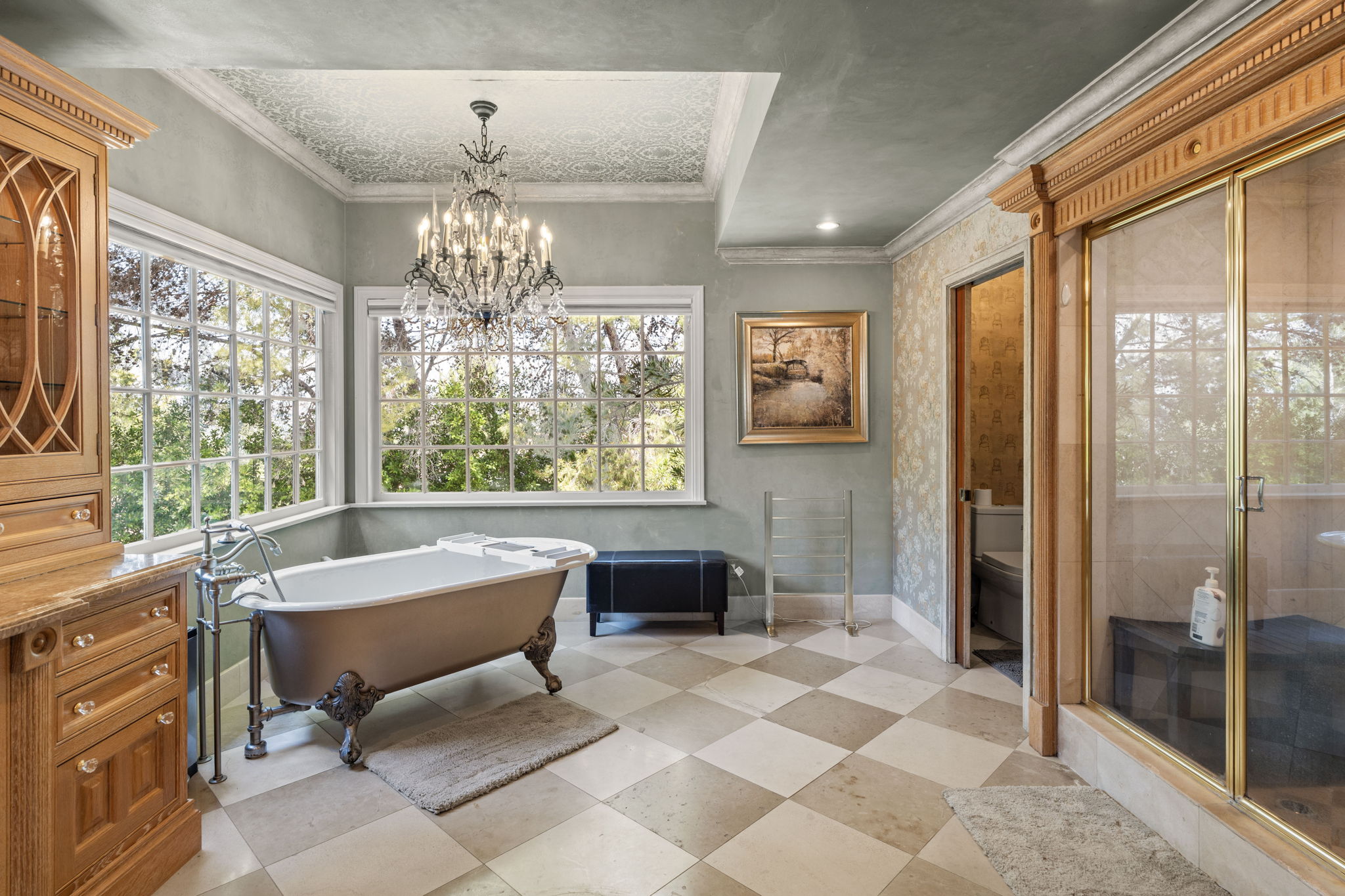 Clawfoot bathtub positioned beneath a window with garden views