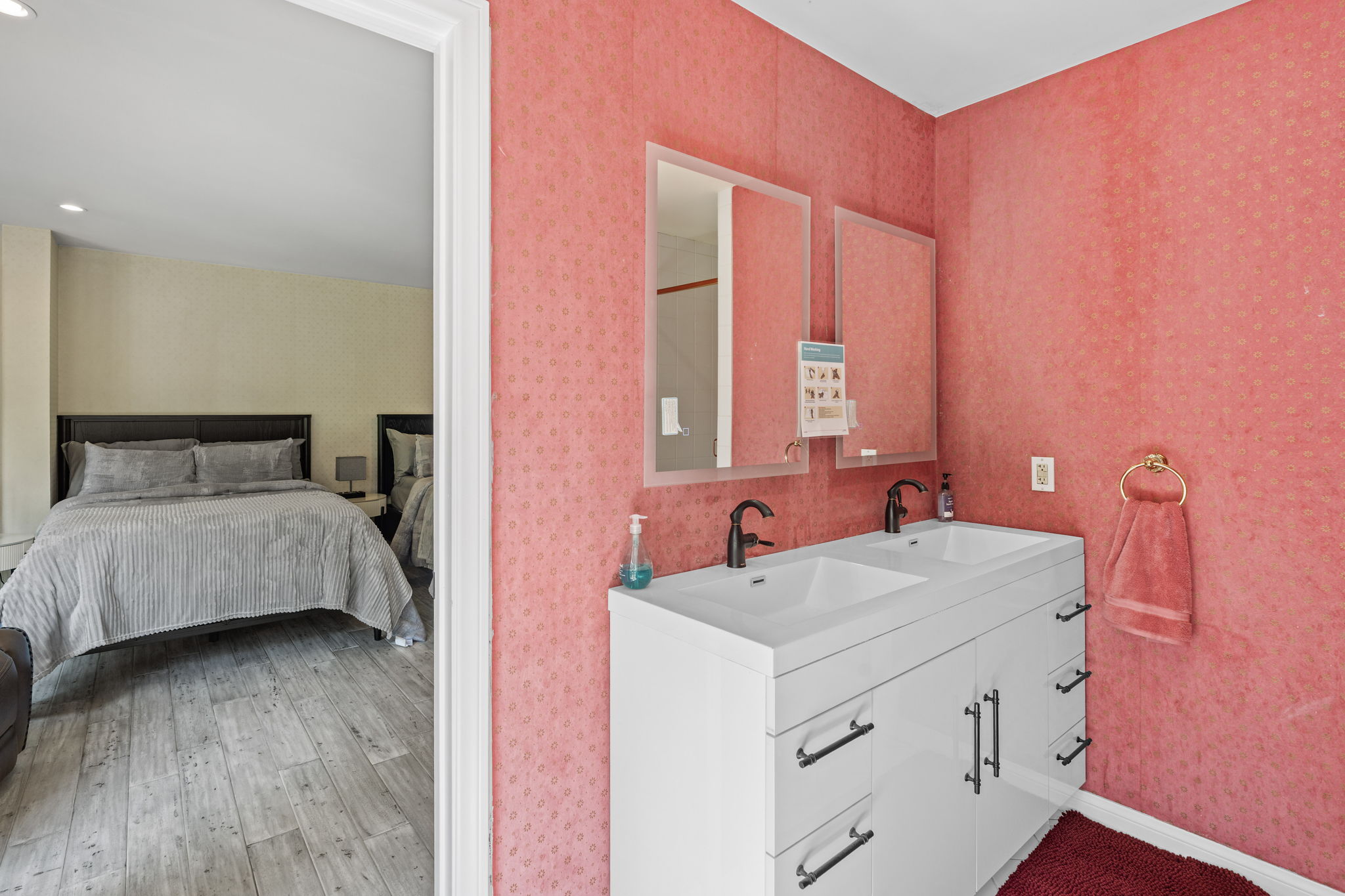 En-suite bathroom with double vanity and coral accent tones