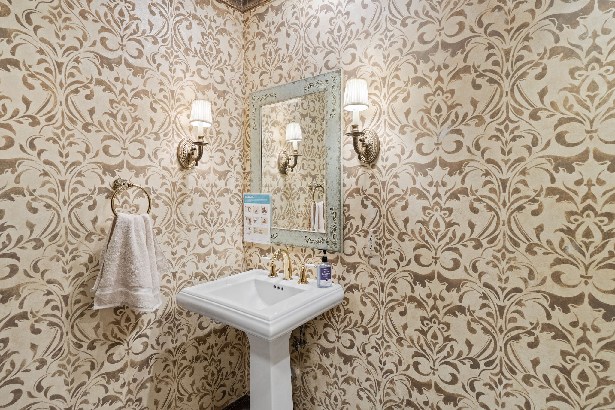 Powder room with damask wallcovering and detailed fixtures